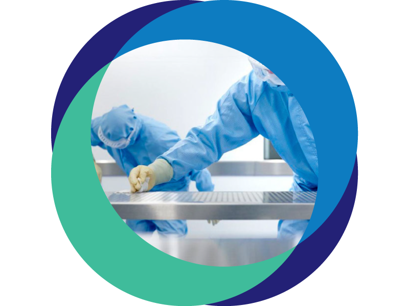 Two people in blue cleanroom suits providing cleaning solutions to wipe down a stainless steel surface. Showing the sustainable laundry solutions provided to them.
